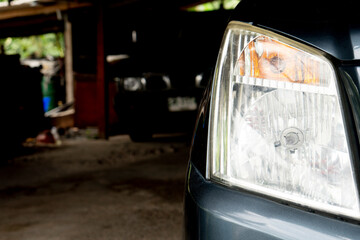 Wall Mural - Close up of car headlight that becomes cloudy after a long time use. Cars parked in the parking lot.