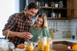 © NDABCREATIVITY - Happy caucasian father and daughter preparing cookie in kitchen. Cooking together happy family time.