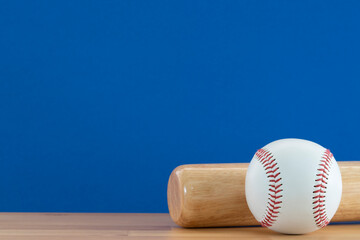 Wall Mural - Close up baseball and baseball bat on wooden table with blue copy space background, sport concept