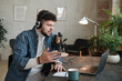 © AnnaStills - Mature bearded radio dj in headphones broadcasting at the table working on radio
