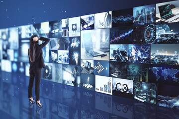 Poster - Broadcasting concept with pensive businesswoman looking at media wall with variation of video.