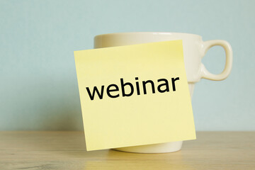 The word webinar. Mug, paper sticky note with copy space. coffee is always a good idea.