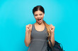 © luismolinero - Young sport Russian girl with sport bag isolated on blue background celebrating a victory in winner position