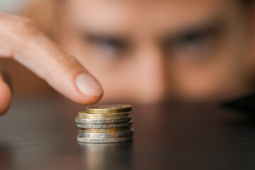 Man counting coins at table, closeup. Bankruptcy concept