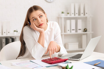 Canvas Print - Bored female accountant with calculator working in office