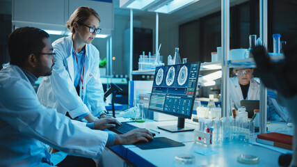 Wall Mural - Female Research Scientist Has a Conversation with Bioengineer About the Effects of Different Pharmaceutical Drugs on Brain. They Look at Computer Software Visualization in a Modern Science Laboratory.