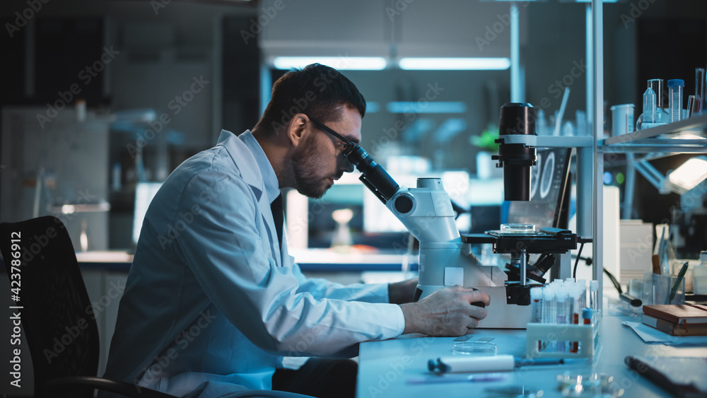 Medical Development Laboratory: Caucasian Female Scientist Looking Under Microscope, Analyzes Petri Dish Sample. Specialists Working on Medicine, Biotechnology Research in Advanced Laboratory - obrazy, fototapety, plakaty 