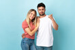 © luismolinero - Young caucasian couple isolated on blue background frustrated and pointing finger to the side