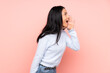 © luismolinero - Teenager Chinese woman isolated on pink background shouting with mouth wide open to the side
