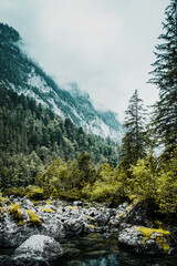 Wall Mural - Moody mountain scene on a dark rainy weather spring day with low hanging clouds. Alps mountains, Austria