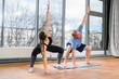 © o_lypa - Young girl and mature aged man stand on mat with wide bent legs barefoot in studio with panoramic window.