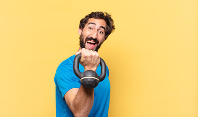 young crazy bearded athlete young crazy bearded athlete happy expression and lifting a dumbbell