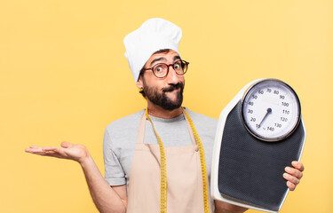 young bearded chef man doubting or uncertain expression and holding a scale