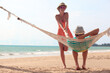 © el.rudakova - Young romantic couple relaxing in hammock on tropical beach in Thailand