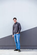 © Clare Seibel-Barnes/Austockphoto - Person standing beside wall in urban area - full length body shot of young man