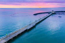 Aerial View Of A Dramatic Purple Sunset Over A Coastal Jetty And Breakwater
