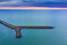 Aerial View A Breakwater In A Calm Bay At Sunset