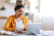 © Kateryna - Smart attractive happy mixed race black girl with dreadlocks, in casual clothes, studying remotely, watching online briefing, talking on conference call with teacher or colleagues, smiling