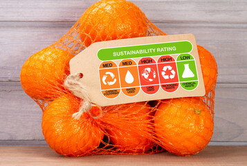 Wall Mural - Consumer environmental sustainability rating label on bag of oranges with high, med and low ratings for food carbon footprint, water use, land use, packaging waste and chemical waste label.