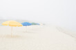 © Chris Hackett/Tetra Images - Empty beach with umbrellas and fog