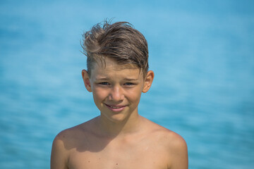 young boy is enjoying on the beautiful tropical beach at summer, close up portrait