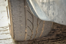 Old Tire With Worn Tread And Scratch, Worn Old Car Tire Tread With Damaged, Scratch, Worn Tire Tread In The Car Wheel