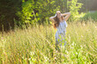 © satura_ - Happy young woman with long hair in hat and dress walking through the summer forest on a sunny day. Summer joy concept