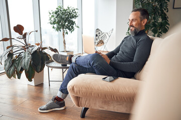 Wall Mural - Happy adult caucasian man is working in a modern office