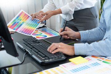 Poster - graphic designer or creative working together coloring using graphics tablet and a stylus at desk wi