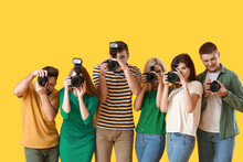 Group Of Young Photographers On Color Background