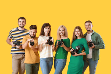  Group of young photographers on color background