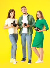 Poster - Group of young photographers on color background