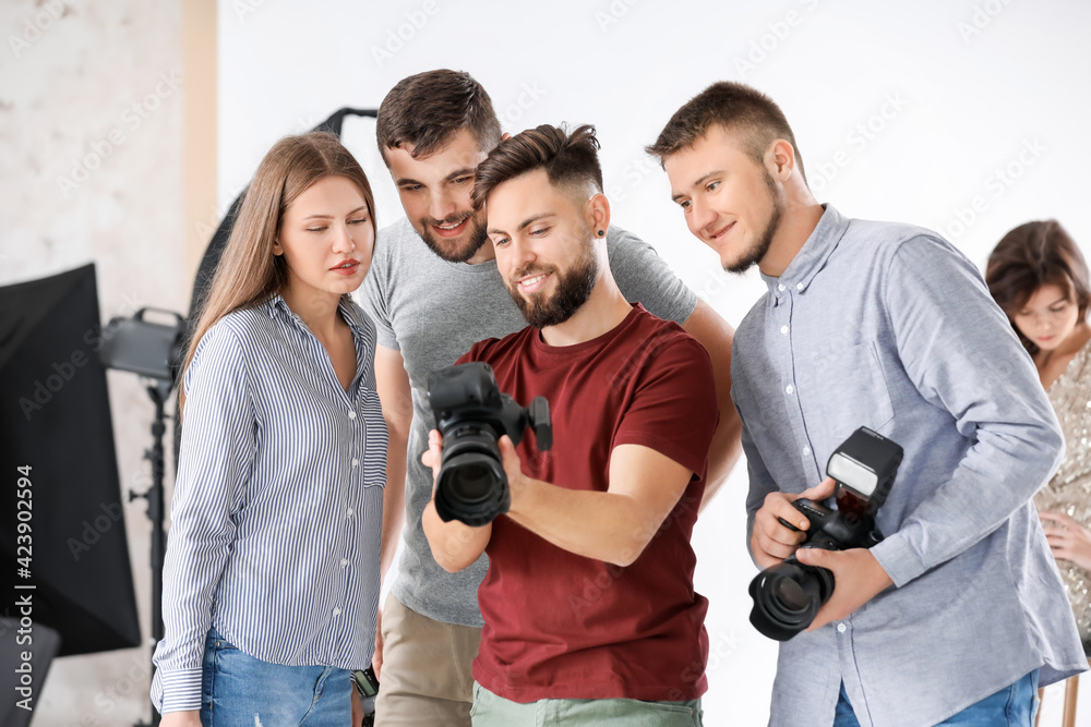 Mentor teaching young photographers in studio