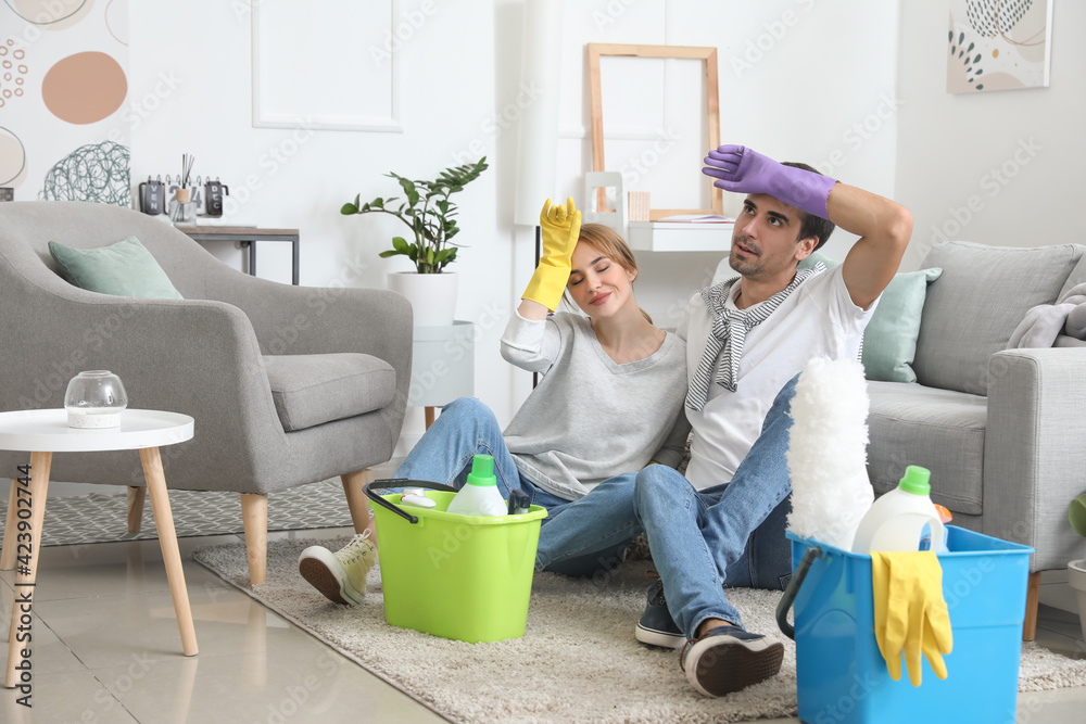 Young couple resting after cleaning their flat