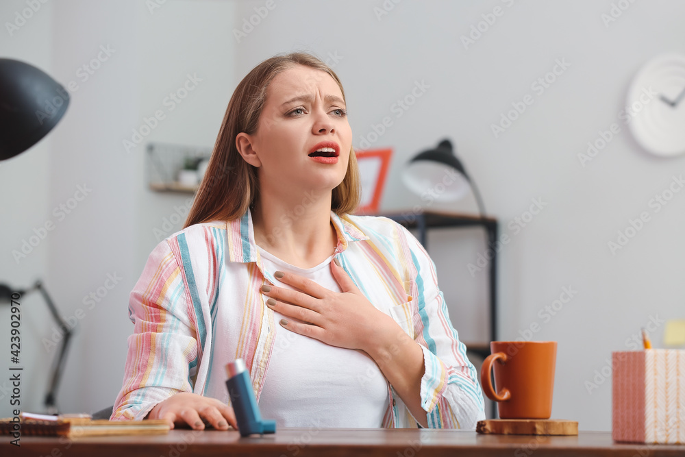 Young woman having asthma attack at home