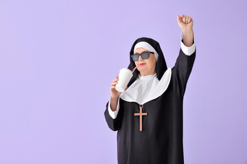 Wall Mural - Funny senior nun with soda on color background