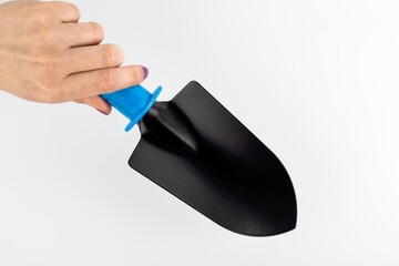 Shovel for gardening in a woman's hand on white background