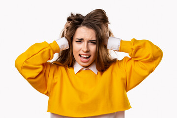 Portrait of woman in panic shouting and grabbing her head in fear or frustration. Studio shot, white background