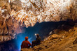 Spelunkers wondering and admiring stalactites in a cave