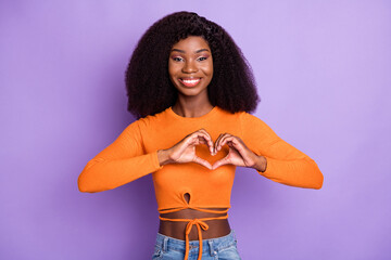 Poster - Photo of cute pretty young woman dressed orange crop top showing fingers heart isolated purple color background