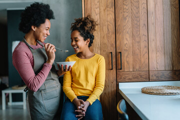 Wall Mural - Mother and daughter happy together at home in kitchen