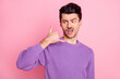 Portrait of attractive irritated arrogant guy showing phone sign like calling isolated over pink pastel color background