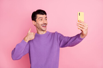 Sticker - Photo of funny charming man dressed purple pullover showing thumb up tacking selfie modern device isolated pink color background