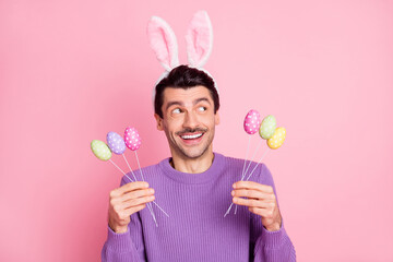 Sticker - Photo of sweet funky young man dressed purple pullover hare ears eggs sticks looking empty space isolated pink color background