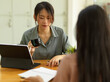 © bongkarn - Portrait of two female office worker consulting other work while sitting opposite each other
