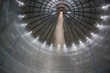 grain storage silo inside view. grain is poured into the warehouse. storage of bulk food products.