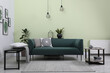 © New Africa - Stylish living room interior with comfortable green sofa and floral pictures