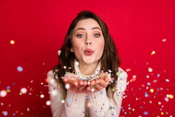 Poster - Photo of sweet charming young woman dressed white sweater blowing arms sparkles isolated red color background