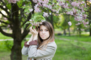 girl near blooming sakura. Spring is now. Cherry blossoms. Sakura at dusk. portrait at sunset