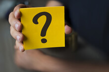 Hand Holding A Yellow Paper With A Question Mark - Why?, Business Concept